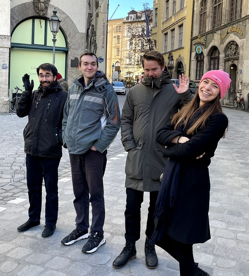 Julian steht mit Kolleg:innen in einer sonnigen Altstadtstraße, alle lachen und winken. Ein spontaner Schnappschuss, der das Teamgefühl bei appsoluts zeigt.
